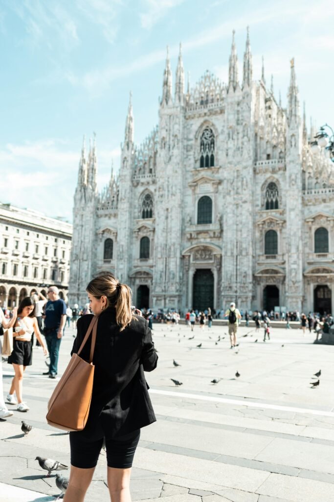Tourists enjoy a sunny day in front of the stunning Milan Cathedral, Italy's architectural marvel.